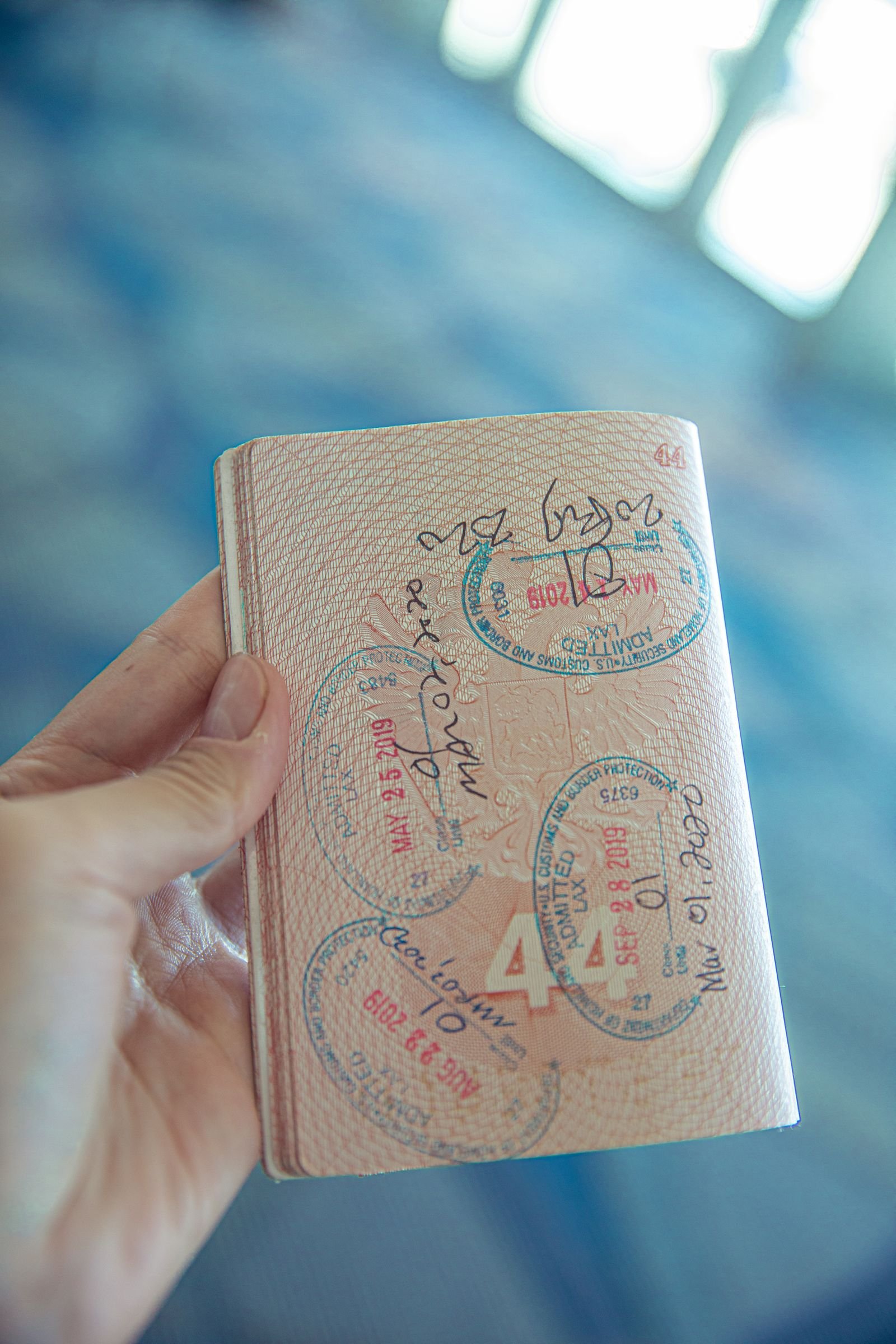 Como tirar o passaporte em 2026: pessoa segurando um passaporte aberto
