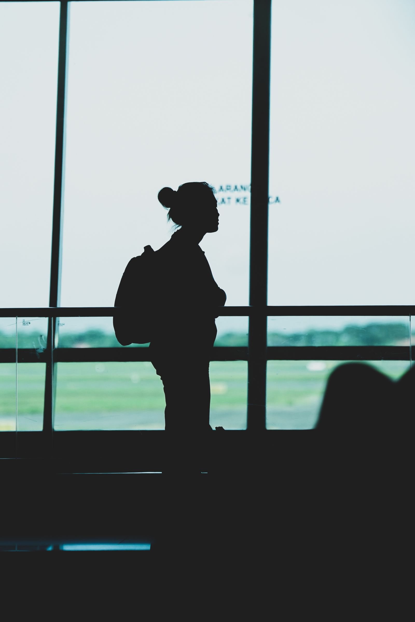 Planejar uma viagem internacional: viajante com mochila em terminal de aeroporto
